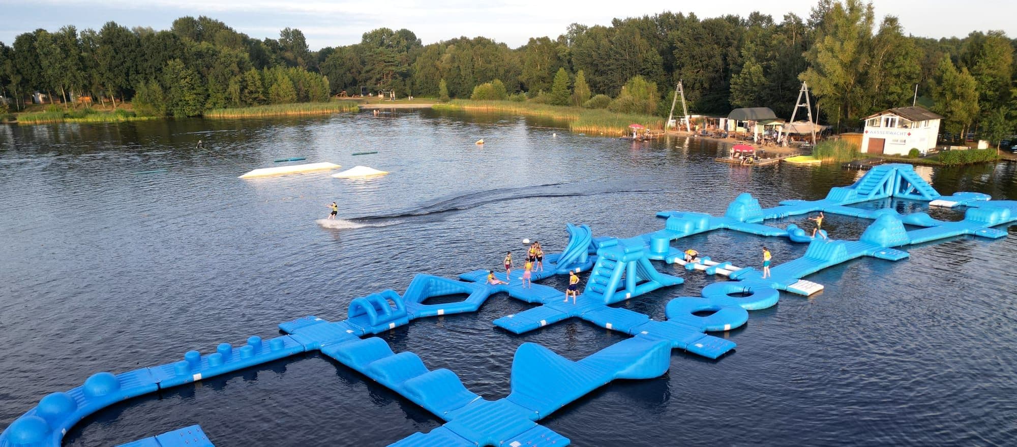 Luftaufnahme des Oyter Sees mit Aquapark und Wakeboarder an der Seilbahn